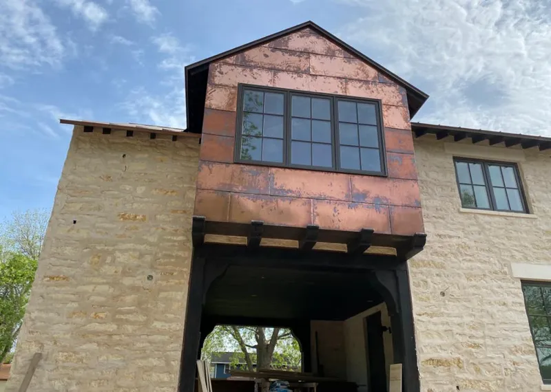 Copper metal panel facade on a stone building for Roof Repair in College Station