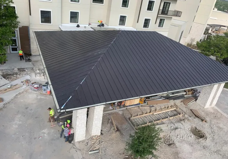 Metal roofing installation team working on a commercial building in College Station